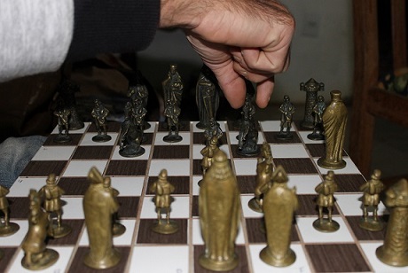 Vista lateral de dois jogadores de xadrez apertando as mãos sobre o  tabuleiro de xadrez após a partida dia mundial do xadrez